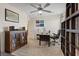 This home office is furnished with a ceiling fan, desk, rolling chair, and stylish cabinet with dark wood at 6848 Sunflower Fields St, North Las Vegas, NV 89086
