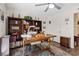 Bright office space featuring a large desk, custom bookshelves, and a ceiling fan, perfect for working from home at 6848 Sunflower Fields St, North Las Vegas, NV 89086