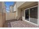 Enclosed patio with brick pavers, gray stucco, and low-maintenance rock landscaping at 6848 Sunflower Fields St, North Las Vegas, NV 89086
