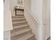 Carpeted staircase with white walls leads to the upper level of the home with a charming, neutral palette at 6848 Sunflower Fields St, North Las Vegas, NV 89086