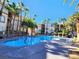 Community pool surrounded by lounge chairs and palm trees at 7135 S Durango Dr # 314, Las Vegas, NV 89113