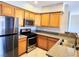 Well-lit kitchen with wood cabinetry, stainless steel appliances, and stone countertops at 7135 S Durango Dr # 314, Las Vegas, NV 89113