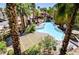 Aerial view of a community pool, patio furniture, and lush landscaping between condo buildings at 7173 S Durango Dr # 307, Las Vegas, NV 89113