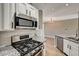 Modern kitchen featuring stainless steel gas range and oven with granite countertop, white cabinets, and tile backsplash at 7173 S Durango Dr # 307, Las Vegas, NV 89113