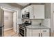 Modern kitchen featuring stainless steel gas range and oven with granite countertop, white cabinets, and tile backsplash at 7173 S Durango Dr # 307, Las Vegas, NV 89113