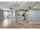 Open living space with wood floors, modern light fixture, kitchen with stainless steel appliances, and access to balcony at 7173 S Durango Dr # 307, Las Vegas, NV 89113