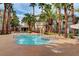 Inviting outdoor pool surrounded by lush palm trees and a relaxing seating area at 7173 S Durango Dr # 307, Las Vegas, NV 89113