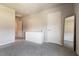 Bright bedroom with neutral walls and plush carpeting with a large mirror leaning against the wall at 7302 Sunray Point St, North Las Vegas, NV 89084
