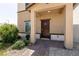 Inviting entryway showcasing a covered porch, a dark wood door, and well-maintained landscaping at 7302 Sunray Point St, North Las Vegas, NV 89084