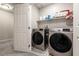 Convenient laundry room equipped with modern washer and dryer units, plus storage shelves for supplies at 7302 Sunray Point St, North Las Vegas, NV 89084