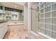 Bathroom features tub, standing shower with glass blocks, and dual vanity with large mirrors at 8411 Carmel Ridge Ct, Las Vegas, NV 89113