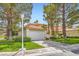 Two-story home features a garage, lush green lawn, and mature landscaping at 8411 Carmel Ridge Ct, Las Vegas, NV 89113