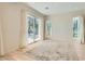 Open living area with light hardwood floors, large windows, and neutral curtains at 8411 Carmel Ridge Ct, Las Vegas, NV 89113
