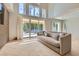 Sun-drenched living room features floor to ceiling windows, a modern sofa, and access to the backyard pool at 8411 Carmel Ridge Ct, Las Vegas, NV 89113