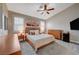 Serene bedroom featuring a king-size bed, ceiling fan, dresser, and ample natural light from the windows at 8719 Villa Ariel Ln, Las Vegas, NV 89147