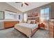 Bedroom with a king-size bed, matching dresser, ceiling fan, and ample natural light from the windows at 8719 Villa Ariel Ln, Las Vegas, NV 89147