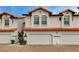 Charming townhome exterior with a brick driveway, white facade, and terracotta roof tiles at 8719 Villa Ariel Ln, Las Vegas, NV 89147