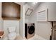 Compact laundry room featuring a washer, dryer, toilet, and storage cabinets for efficient use of space at 8719 Villa Ariel Ln, Las Vegas, NV 89147