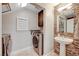 Functional laundry room with modern washer and dryer, complemented by a pedestal sink and mosaic tile wall at 8719 Villa Ariel Ln, Las Vegas, NV 89147