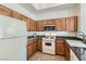 Well-lit kitchen with wooden cabinets, white appliances, and granite countertops at 8805 Jeffreys St # 2073, Las Vegas, NV 89123
