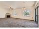 Large living room featuring fireplace, plush carpet, multiple windows, access to kitchen, and sliding glass door to patio at 8805 Jeffreys St # 2073, Las Vegas, NV 89123