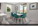 Cozy dining room with a white table, teal chairs, and sliding glass doors at 9687 Biedler Ct # Lot 2, Las Vegas, NV 89178