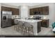 Modern kitchen featuring an island with seating, stainless steel appliances, and dark wood cabinetry at 9687 Biedler Ct # Lot 2, Las Vegas, NV 89178