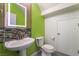 Modern half bath with pedestal sink, mosaic tile, and neon green accent wall at 9753 Villa Lorena Ave, Las Vegas, NV 89147