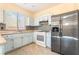 Updated kitchen with stainless steel refrigerator and mosaic tile backsplash at 9753 Villa Lorena Ave, Las Vegas, NV 89147