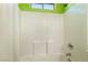 Shower-tub combination features white tile surround and window at 9753 Villa Lorena Ave, Las Vegas, NV 89147