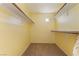 Walk-in closet with carpet flooring, yellow walls and storage shelving at 9753 Villa Lorena Ave, Las Vegas, NV 89147