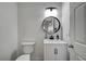 Bathroom featuring a toilet, modern sink vanity, and round mirror at 1001 Domnus Ln # 201, Las Vegas, NV 89144