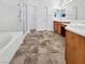 Bright primary bathroom with dual sinks, tile floor, separate shower, and soaking tub at 10056 Cranbrook Falls Ct, Las Vegas, NV 89148