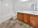 Bathroom features a double sink vanity, white tiled shower-tub combination, and tile flooring at 10056 Cranbrook Falls Ct, Las Vegas, NV 89148