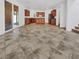 Spacious open kitchen with wooden cabinets, tile floors, and stainless steel appliances, seamlessly connected to the living area at 10056 Cranbrook Falls Ct, Las Vegas, NV 89148