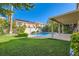 Inviting backyard with lush greenery, a sparkling pool, and shade trees at 10241 Regents Cross Pl, Las Vegas, NV 89144