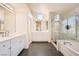 Modern bathroom with dual sinks, a soaking tub, and a separate glass-enclosed shower at 10241 Regents Cross Pl, Las Vegas, NV 89144