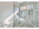 Modern bathroom features a shower with marble-patterned tiles and glass door at 10241 Regents Cross Pl, Las Vegas, NV 89144
