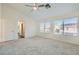Large bedroom featuring neutral carpet, ample natural light, and en-suite bathroom access at 10241 Regents Cross Pl, Las Vegas, NV 89144