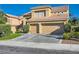 Stylish two-story house includes a two-car garage, verdant lawn, and pruned hedges at 10241 Regents Cross Pl, Las Vegas, NV 89144