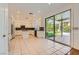 Spacious kitchen with island, black appliances, white cabinetry, tile floor, and access to outdoor pool at 10241 Regents Cross Pl, Las Vegas, NV 89144