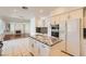 Spacious kitchen with granite countertops, island, tile floors, stainless steel appliances, and view to living room at 10241 Regents Cross Pl, Las Vegas, NV 89144