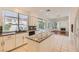 Well-lit kitchen with white cabinets, granite countertops, island, and view to outdoor patio through large window at 10241 Regents Cross Pl, Las Vegas, NV 89144
