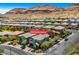 Aerial view of home in residential area nestled against the backdrop of Red Rock offering stunning views and neighborhood charm at 10697 Acacia Park Pl, Las Vegas, NV 89135
