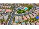 Overhead view of neighborhood with private pools, green landscaping, and a common recreation area including pool and playground at 10697 Acacia Park Pl, Las Vegas, NV 89135