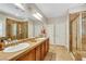 Spacious bathroom with double sinks, glass shower, and tile flooring with modern fixtures at 10697 Acacia Park Pl, Las Vegas, NV 89135