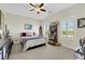 A cozy bedroom features a full bed, ceiling fan, and a collection of charming decorations at 10697 Acacia Park Pl, Las Vegas, NV 89135