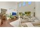 Spacious living room with high ceilings, clerestory windows, neutral colors and cozy furniture at 10697 Acacia Park Pl, Las Vegas, NV 89135