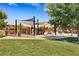 Community playground with colorful play structures, sunshades, and green space for children to play and enjoy outdoor activities at 10697 Acacia Park Pl, Las Vegas, NV 89135