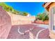 Backyard featuring red rock landscaping, a patio, and a block privacy wall at 11028 Meadow Leaf Ave, Las Vegas, NV 89144